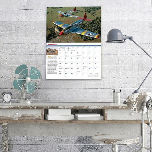 Calendar with airplane design on a wall above a desk.