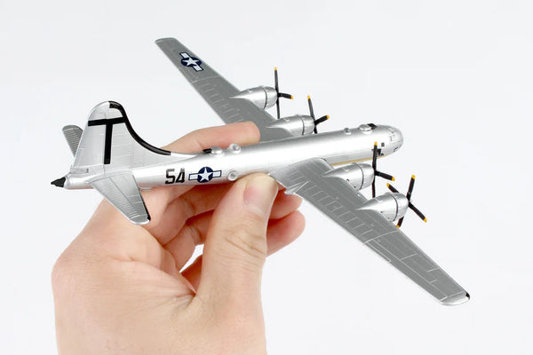 Hand holding a model airplane with a white background