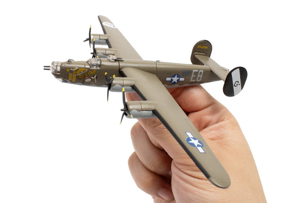 Hand holding a b-24 bomber model airplane with visible branding on a white background