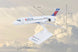 A Delta-branded model airplane displayed on a stand against a cloudy sky background, with measurement lines and labels showing dimensions such as 7.5 in, 7 in, and 11.