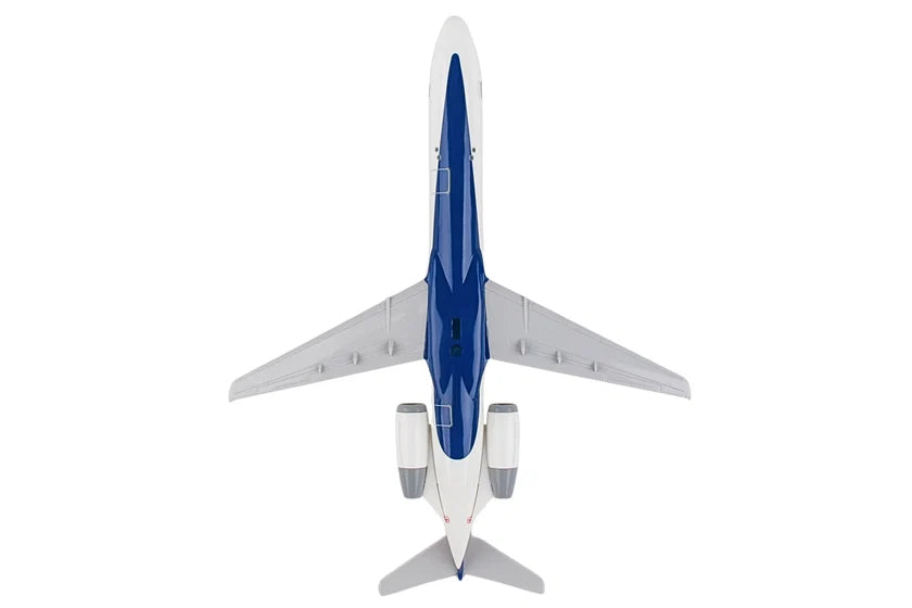 A top-down view of a model airplane, likely a toy or scale model, featuring a white fuselage, blue nose and underbelly, and gray wings and engines, isolated on a white background.