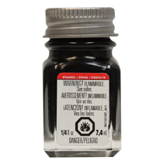 A bottle of Testors TES1147TT Gloss Black Enamel Paint with a label indicating it is 1/4 oz. size, flammable, and made in the USA.