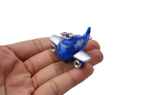 Blue airplane keychain with 'jetBlue' branding held in a hand against a white background