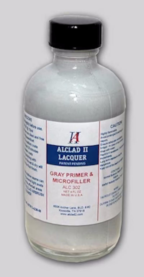 Bottle of Aclad II Lacquer gray primer & microfiller with a black cap on a gray background