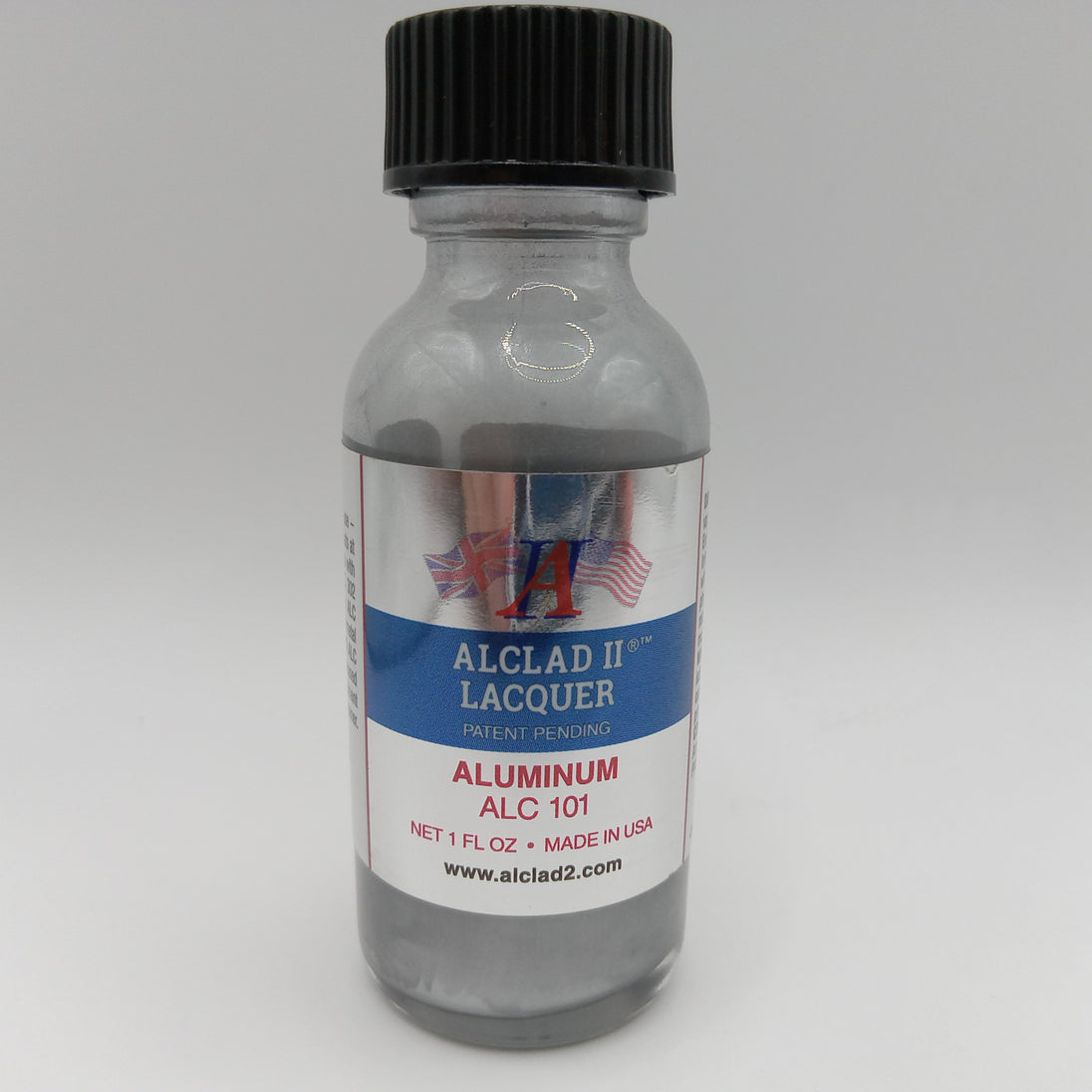 A small clear bottle of Alclad II Lacquer Aluminum Lacquer (ALC 101) with a black ribbed cap and a white, blue, and red label, set against a neutral gray background.