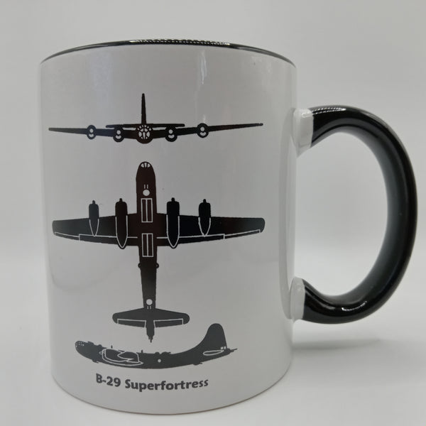 A ceramic coffee mug with a black handle and white body, featuring a silhouette of the B-29 Superfortress aircraft in black.