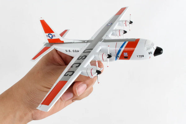 Model airplane held in a hand with a plain background
