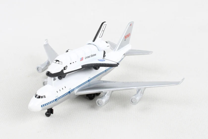 A diecast model toy of a United States Space Shuttle attached to a white and blue Boeing 747 passenger aircraft, photographed on a light gray background.