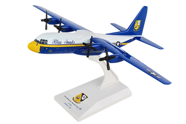 A scale model of a Blue Angels aircraft on a white display stand, featuring a white fuselage with blue and yellow accents, blue wings, and a white tail fin with a blue and yellow emblem.