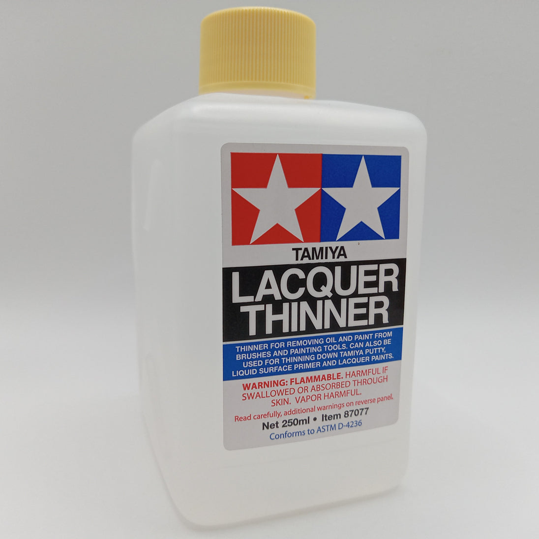 A 250ml bottle of Tamiya Lacquer Thinner with a yellow cap and a white label featuring the red and blue Tamiya logo.