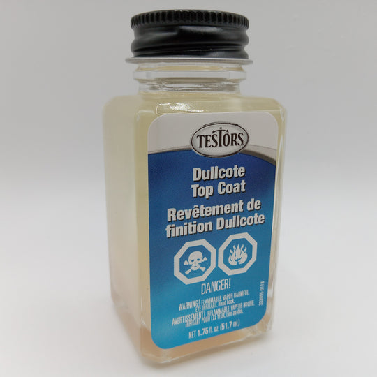 A bottle of Testors Dullcote Top Coat with a black screw cap and a blue and white label, photographed on a light gray background.